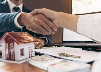 A first-time buyer reviewing rental yields data for Tokyo neighborhoods with a property agent