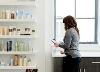 A beauty advisor guides a woman through a double cleanse routine at a Tokyo department store counter