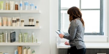 A beauty advisor guides a woman through a double cleanse routine at a Tokyo department store counter
