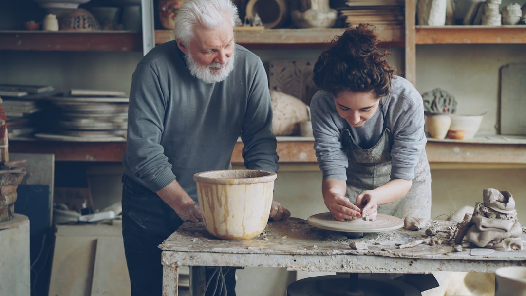 A studio instructor helping a beginner student at a Tokyo workshop pottery class