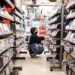 convenience-store-worker-stocking-shelves-japan-unsplash - TOKYOwebzine A konbini culture worker restocking fresh food shelves inside a brightly lit Tokyo convenience store at night