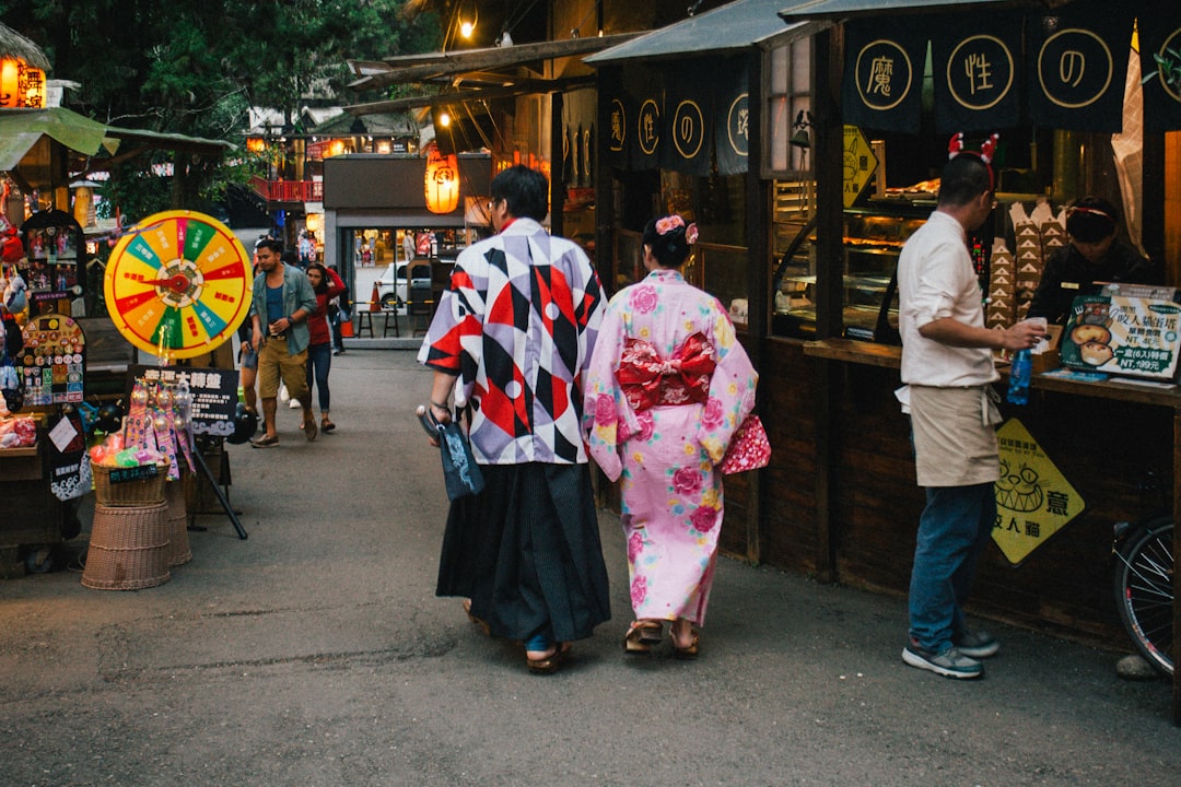 A couple strolls past food stalls at a Japanese summer festival near the Fussa firefly viewing area in western Tokyo