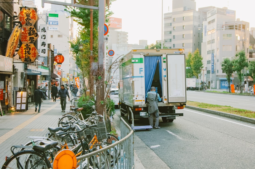 A delivery driver unloading temperature-controlled crates as part of the konbini culture supply chain in Tokyo