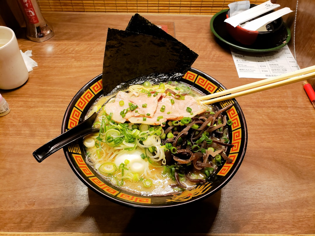 A group of friends sharing gluten-free udon noodles at a small Tokyo restaurant, celebrating safe and delicious dining.