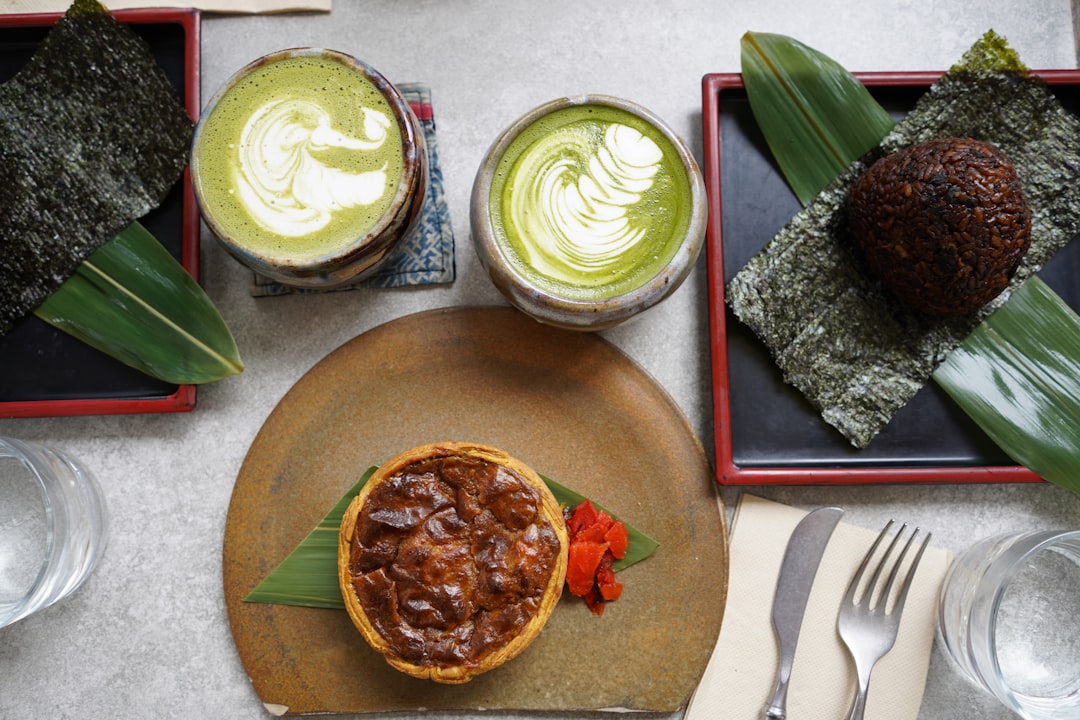 Una cliente esamina la sua ciotola di kakigori al matcha, osservando il colore del dolce di stagione prima del primo cucchiaio.
