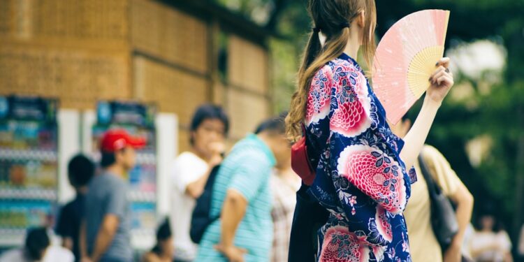 japanese-woman-folding-fan-summer-unsplash - TOKYOwebzine A woman in Tokyo uses a traditional folding fan to stay cool on a hot summer day, a simple ritual that works beautifully.