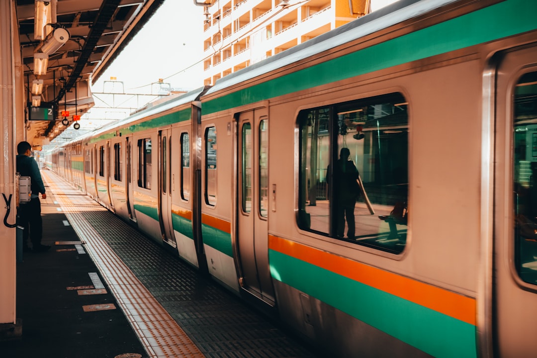 A man checks his phone at a Tokyo train station platform before traveling to the Hanabi Tokyo show in Fuchu.
