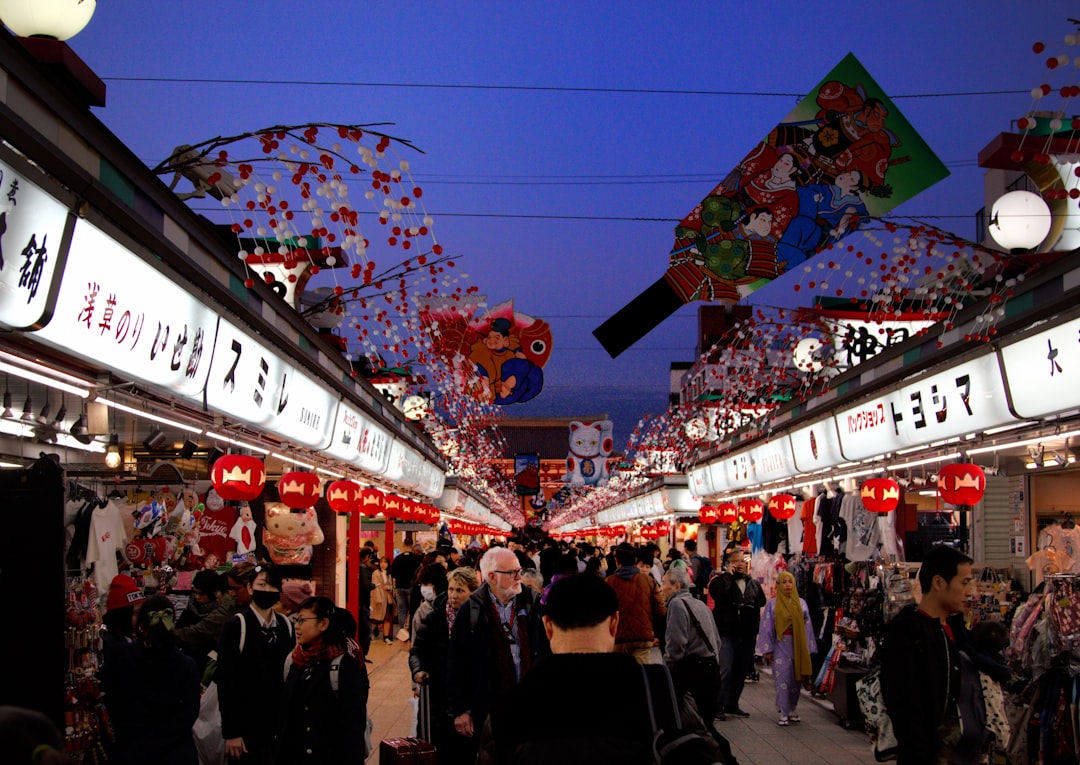 Visitors walk beneath colorful bamboo streamers at a Tanabata Tokyo street festival in summer