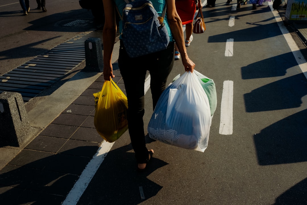 A resident in Tokyo holding transparent bags ready for trash sorting on collection day outside an apartment building