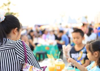 A woman enjoys authentic cuisine at one of the international food festivals held in Tokyo's parks in June.