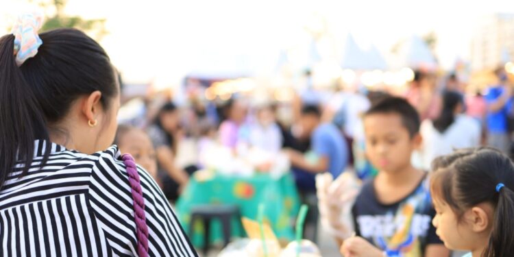 A woman enjoys authentic cuisine at one of the international food festivals held in Tokyo's parks in June.
