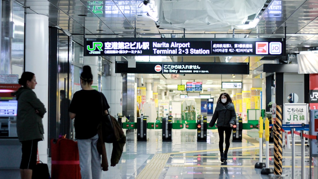 A woman presents her passport at a Japanese airport immigration counter before paying the departure tax