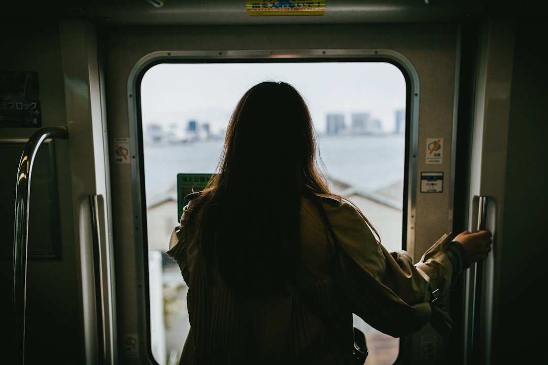 A woman gazes through a train window on her way to a Fussa firefly viewing evening in western Tokyo