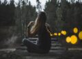 woman-watching-fireflies-river-night-unsplash - TOKYOwebzine A woman stands quietly beside the River during a Fussa firefly viewing evening, watching soft lights reflect on the water