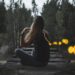 woman-watching-fireflies-river-night-unsplash - TOKYOwebzine A woman stands quietly beside the River during a Fussa firefly viewing evening, watching soft lights reflect on the water