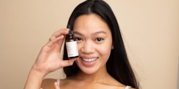 A woman applying lightweight serum as part of her humid skin care morning routine in Tokyo