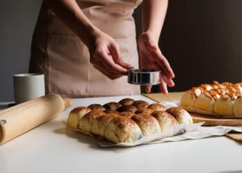 A baker slices a thick loaf of milk bread in a Tokyo bakery, showing its soft and pillowy crumb