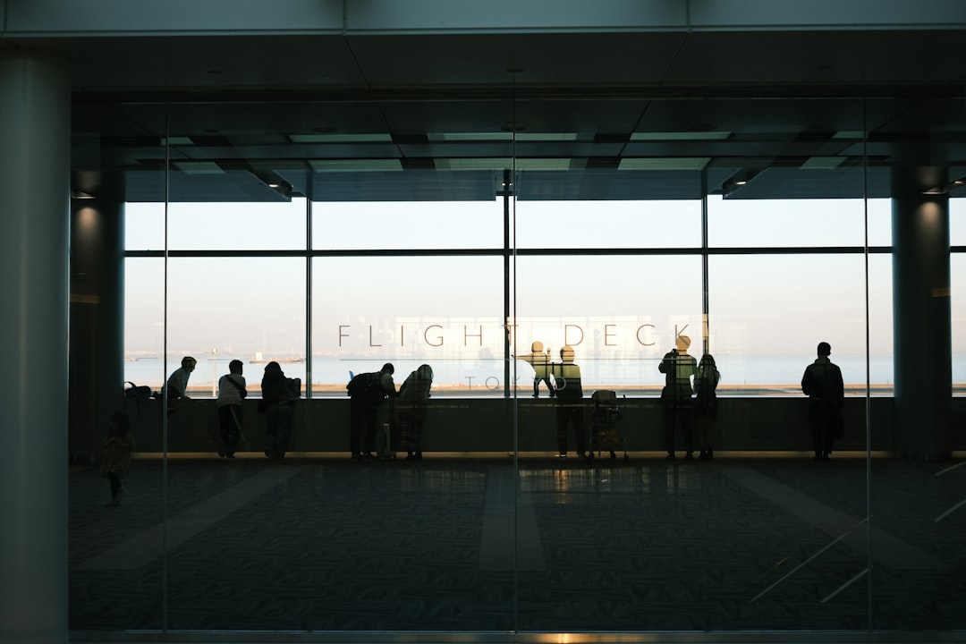 Business travelers walk through a Tokyo airport terminal, reflecting the city's role as a leading Tokyo headquarters