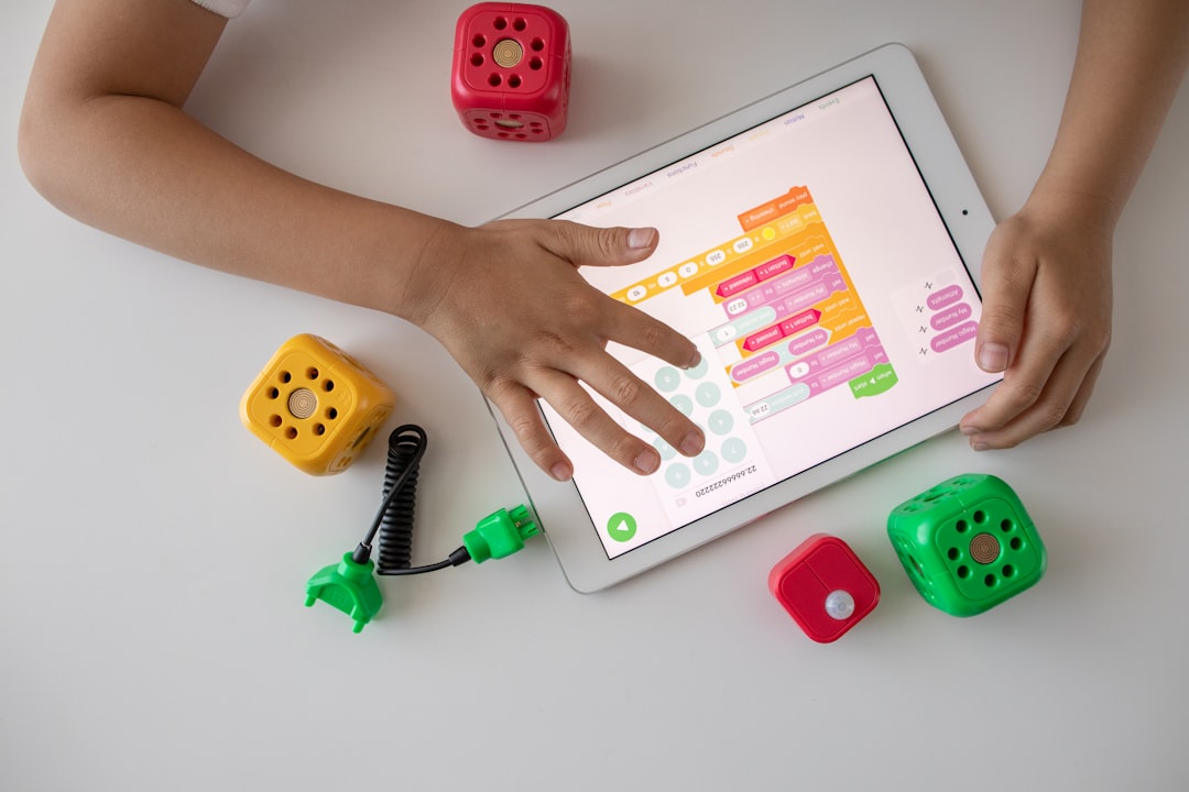A child assembles a small robot at a desk, reflecting the technology-focused kids workshops available in Tokyo in July.