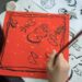 child-painting-traditional-japanese-art-unsplash - TOKYOwebzine A young child concentrates on a brush painting activity during summer kids workshops in Tokyo, surrounded by mineral pigments