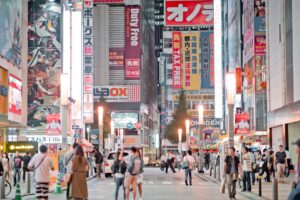 A foreign founder signing Japan trademark registration documents with a Japanese attorney in a Tokyo office