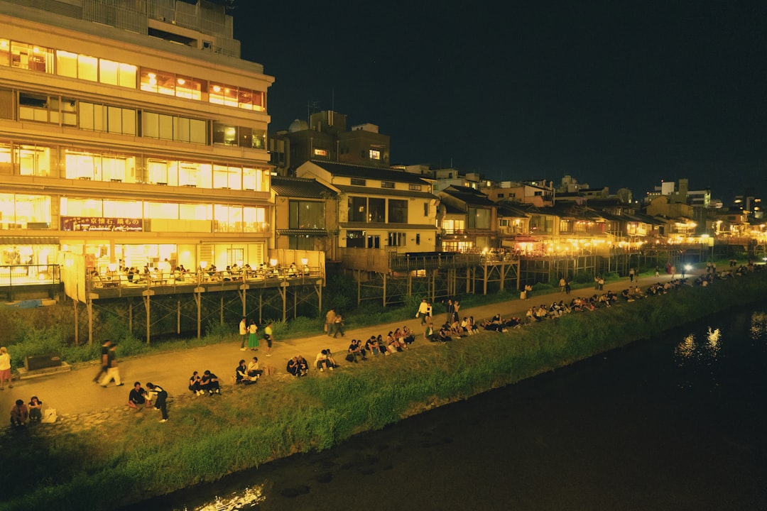 A family with picnic mat enjoying Tokyo hanabi spots along the Edogawa River at dusk