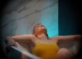 A woman in a float therapy pod at a Tokyo wellness studio, preparing for a session of sensory rest.