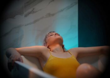 A woman in a float therapy pod at a Tokyo wellness studio, preparing for a session of sensory rest.