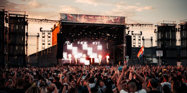 idol-festival-crowd-unsplash - TOKYOwebzine A performer on stage at Tokyo Idol Festival with a large crowd of fans cheering in the Odaiba waterfront venue