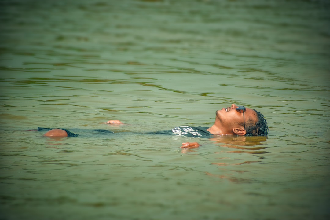 A guest floats peacefully in warm salt water during a float therapy session, eyes closed in stillness.