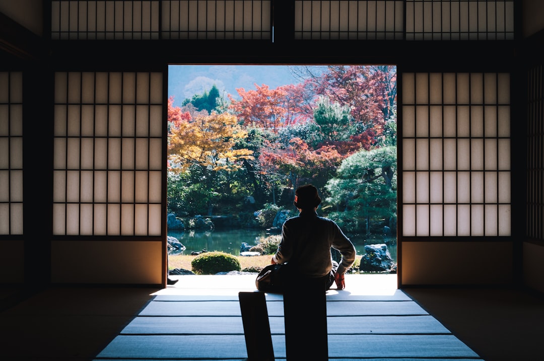 A visitor rests near the red torii gates of Nezu Shrine, a peaceful shitamachi landmark in central Tokyo