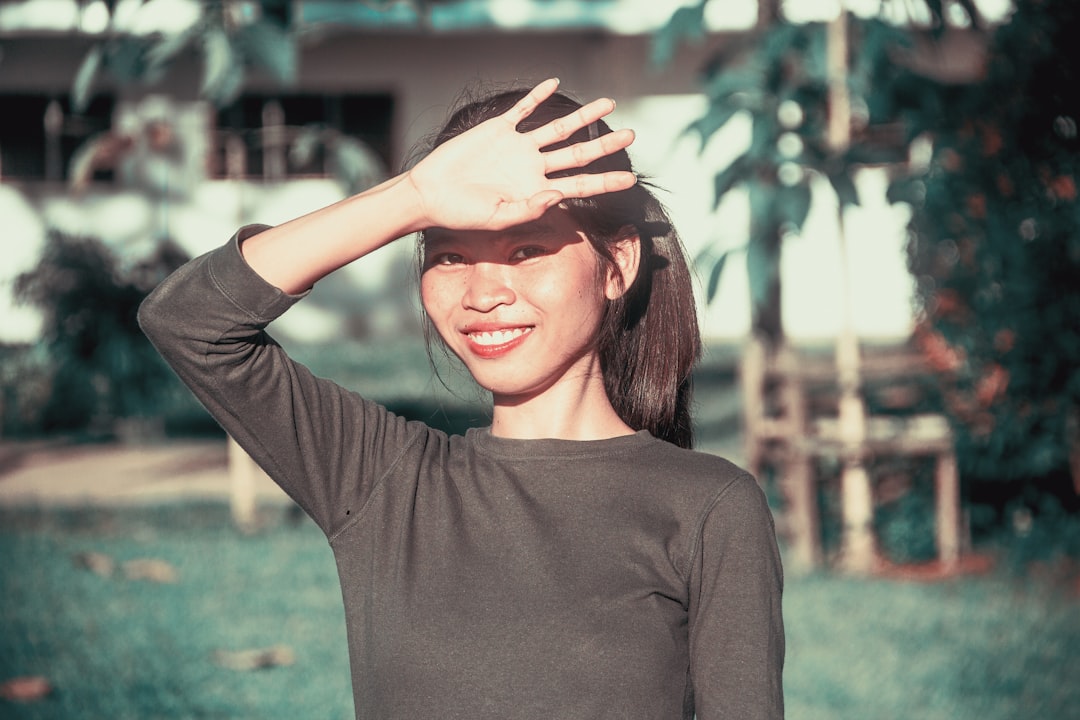 A woman reapplying sunscreen outdoors during Tokyo's peak humid skin care moment of the day