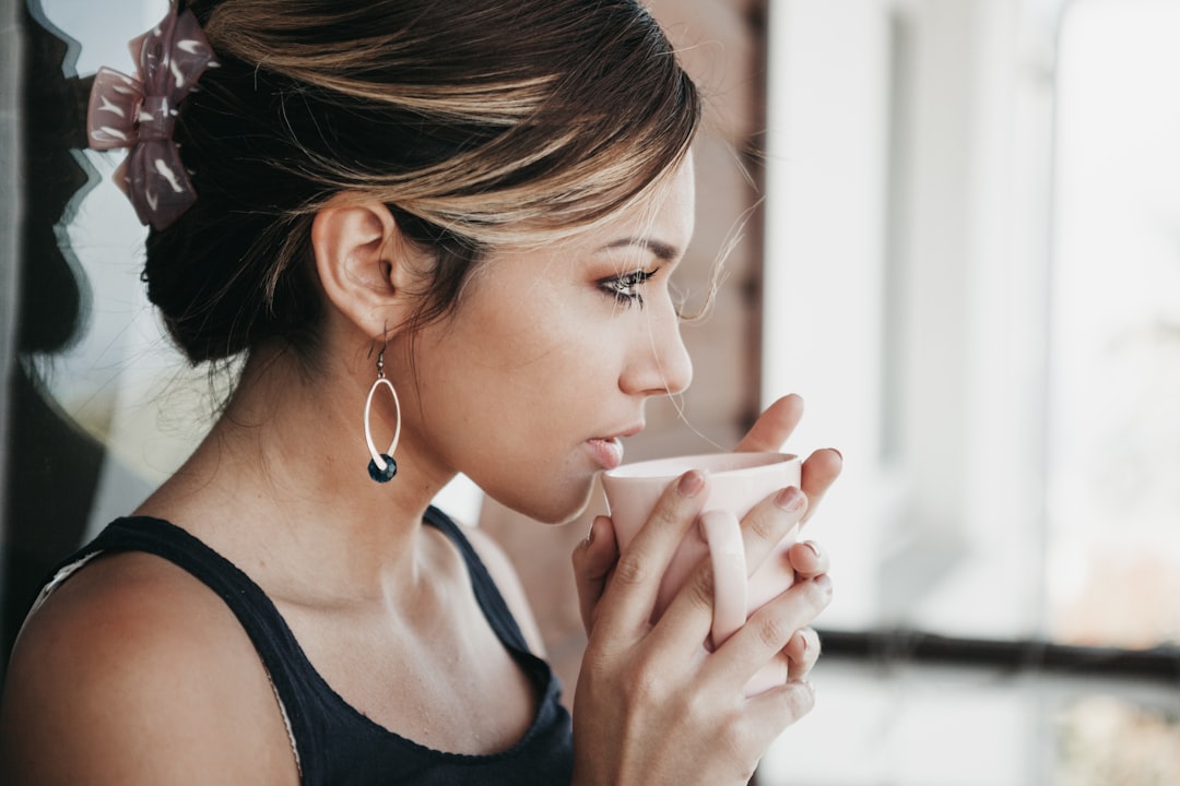 A woman holds a warm cup of tea after completing a float therapy session at a Tokyo studio, looking rested and calm.