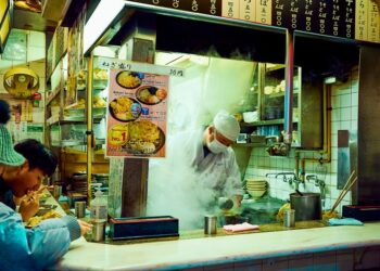 People in a Tokyo soba restaurant, dipping the chilled buckwheat noodles into a ceramic cup of dashi sauce.