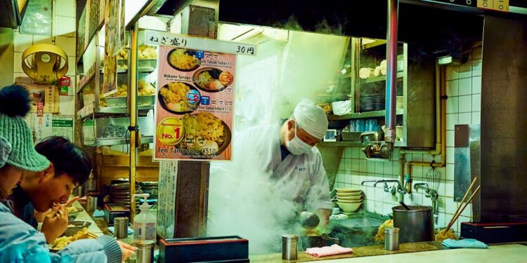 woman-eating-soba-noodles-tokyo-restaurant-unsplash - TOKYOwebzine People in a Tokyo soba restaurant, dipping the chilled buckwheat noodles into a ceramic cup of dashi sauce.