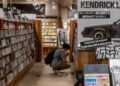 A woman sits quietly in a Tokyo listening bar, experiencing kissa culture through vinyl played on a hi-fi system