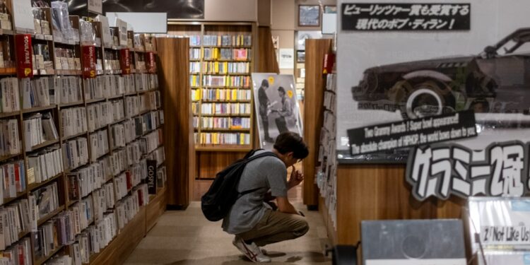 A woman sits quietly in a Tokyo listening bar, experiencing kissa culture through vinyl played on a hi-fi system