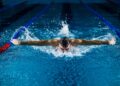 A woman swimming laps in a Tokyo public pool as part of her cold water morning routine