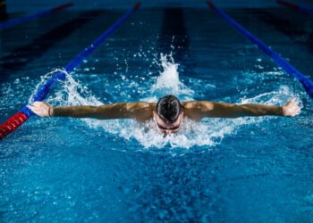 A woman swimming laps in a Tokyo public pool as part of her cold water morning routine