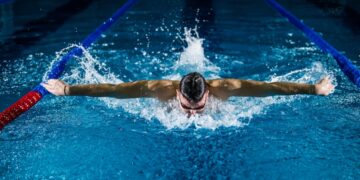 A woman swimming laps in a Tokyo public pool as part of her cold water morning routine