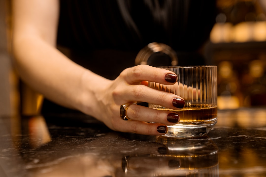 A guest savors a rare Japanese whisky flight at an intimate Tokyo hotel bar, glass raised to the light