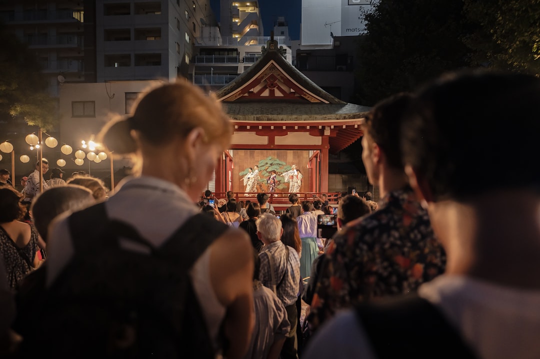 A visitor in traditional dress enjoying the Sumida River hanabi festival among thousands of spectators