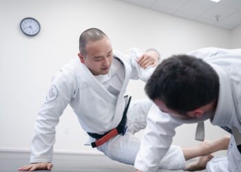 An adult beginner receives English instruction from a sensei at a Tokyo dojo during a karate class
