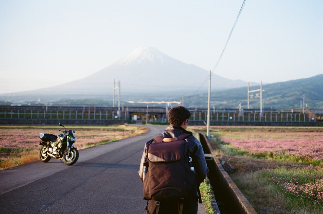 A hiker in warm layers reviews their equipment before Mt Fuji climbing, standing at a mountain hut on the trail.
