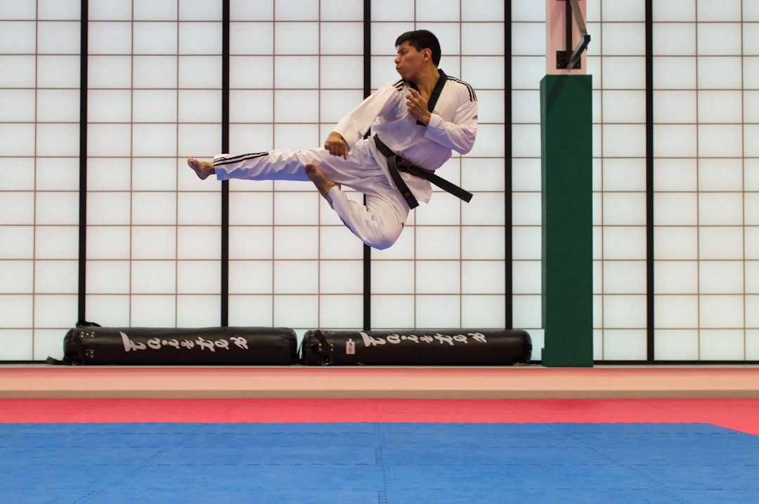 2 adult students practice a judo throw on the mat at a Tokyo dojo under English-speaking supervision