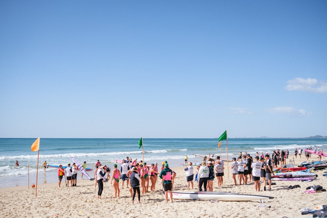 A smiling athlete walking out of the ocean after completing an open water swimming race on the Japanese coast