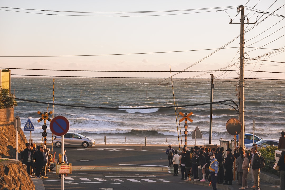 A group of participants at a coastal open water swimming race in Japan, preparing at the shoreline before the start
