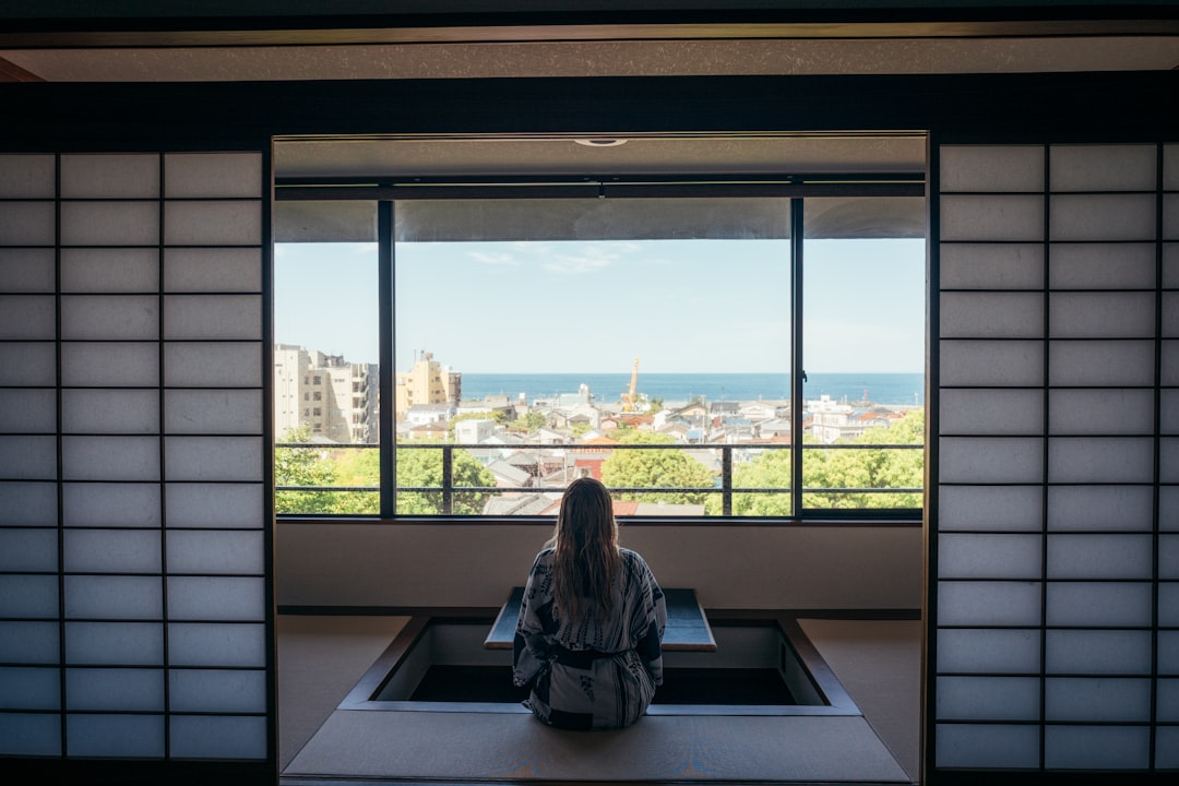 A person slides open a shoji screen to let morning light into a minimalist Tokyo apartment