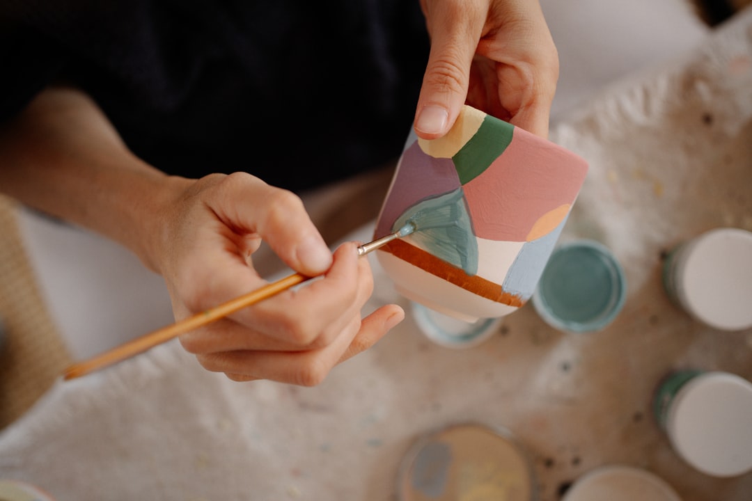 A participant applies gold lacquer to a cracked ceramic bowl at a Tokyo repair café kintsugi station.