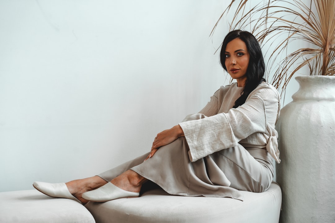 A person wearing a natural-dye linen outfit that forms the core of a seasonless capsule wardrobe